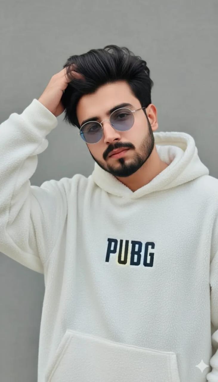 A young man in a trendy white PUBG hoodie, styled casually with hand in hair, set against a simple grey background.